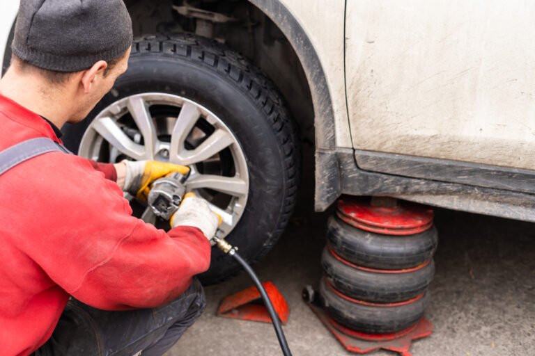 Car mechanic removing wheel nuts to check brakes