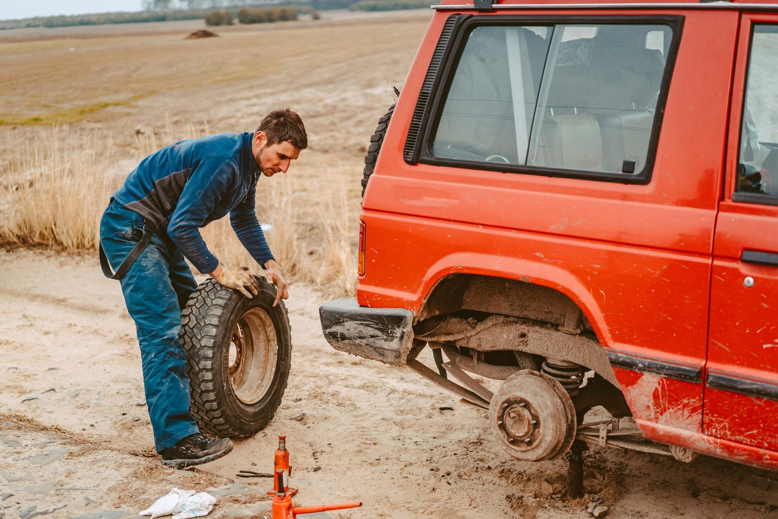 man-change-wheel-manually-4×4-off-road-truck-scaled.jpg